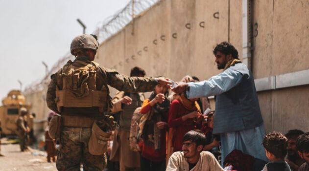 A Marine with the 24th Marine Expeditionary Unit (MEU) passes out water to evacuees during the evacuation at Hamid Karzai International Airport during the evacuation in Kabul, Afghanistan, on Aug. 21, 2021. (Isaiah Campbell/U.S. Marine Corps via Getty Images)