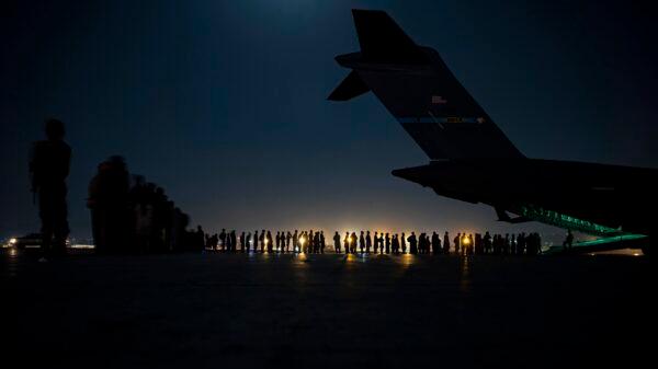 U.S. Air Force aircrew, assigned to the 816th Expeditionary Airlift Squadron, prepare to load qualified evacuees aboard a U.S. Air Force C-17 Globemaster III aircraft in support of the Afghanistan evacuation at Hamid Karzai International Airport, Kabul, Afghanistan, on Aug. 21, 2021. (Senior Airman Taylor Crul/U.S. Air Force via AP)