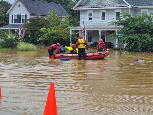 Emergency personnel and first responders work to help residents after heavy rains from Henri flooded the area, in Helmetta, N.J., on Aug. 22, 2021. (Chris Slavicek via AP)