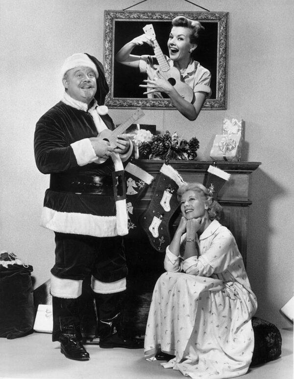 Burl Ives performed in many venues, including television. He appears with Dinah Shore watching Gale Storm strum a ukulele for a Dinah Shore Christmas television special, circa 1955. (Photo by Hulton Archive/Getty Images)