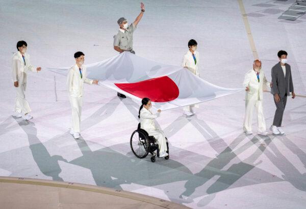 Athletes from Japan Miki Matheson, Mineho Ozaki, Taiyou Imai, Erina Yuguchi, Kaori Icho, and Tskumi Asatani carry the national flag of Japan into the Olympic Stadium at the start of the Paralympic Opening Ceremony Tokyo 2020 Paralympic Games in Tokyo, Japan, on Aug. 24, 2021. (Joe Toth for OIS/via AP)