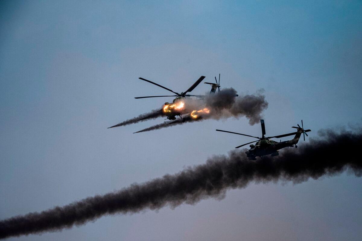 Russian attack helicopters launch rockets during military exercises at the Kapustin Yar range in Astrakhan region, Southern Russia, on Sept. 25, 2020. The "Caucasus-2020" military drills gathered troops from China, Iran, Pakistan, and Burma (Myanmar), along with ex-Soviet Armenia, Azerbaijan, and Belarus. (Dimitar Dilkoff/AFP via Getty Images)