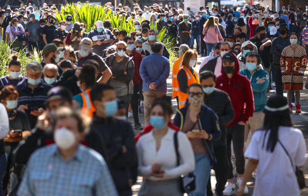 People wearing face masks stand in line as they wait to be vaccinated at the Sydney Olympic Park Vaccination Centre at Homebush in Sydney, Australia, on Aug. 16, 2021. (David Gray/AFP via Getty Images)