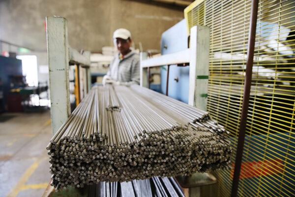 A factory worker moves steel rods at the Multi Slide Industries manufacturing plant in Adelaide, Australia, on Aug. 12, 2013. (Photo by Morne de Klerk/Getty Images)