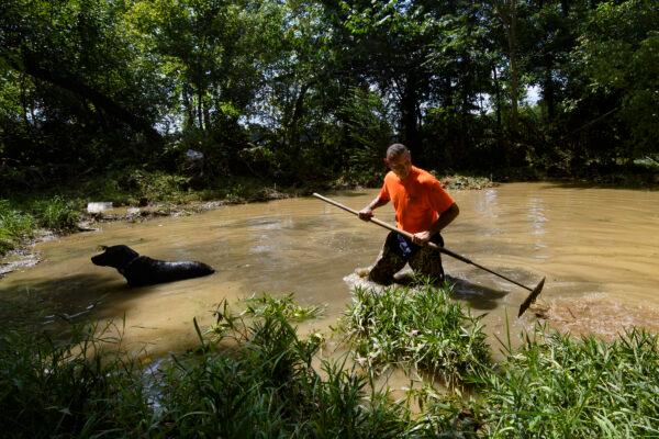 Dustin Shadownes, of Ashland City Fire Department, searches a creek for missing persons along with a cadaver dog in Waverly, Tenn., on Aug. 23, 2021. (John Amis/AP Photo)