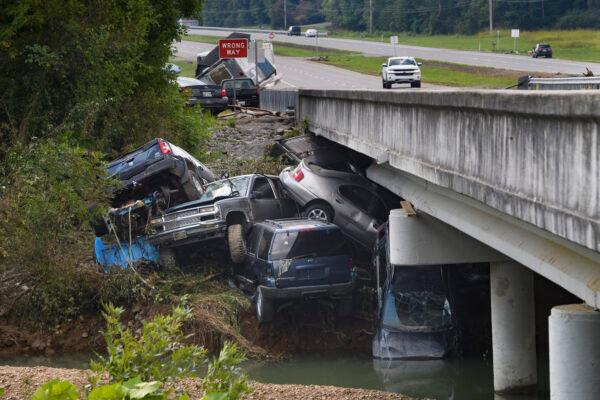 Cars are stacked on top of each other on the banks of Blue Creek, in Waverly, Tenn., on Aug. 23, 2021. (John Amis/AP Photo)