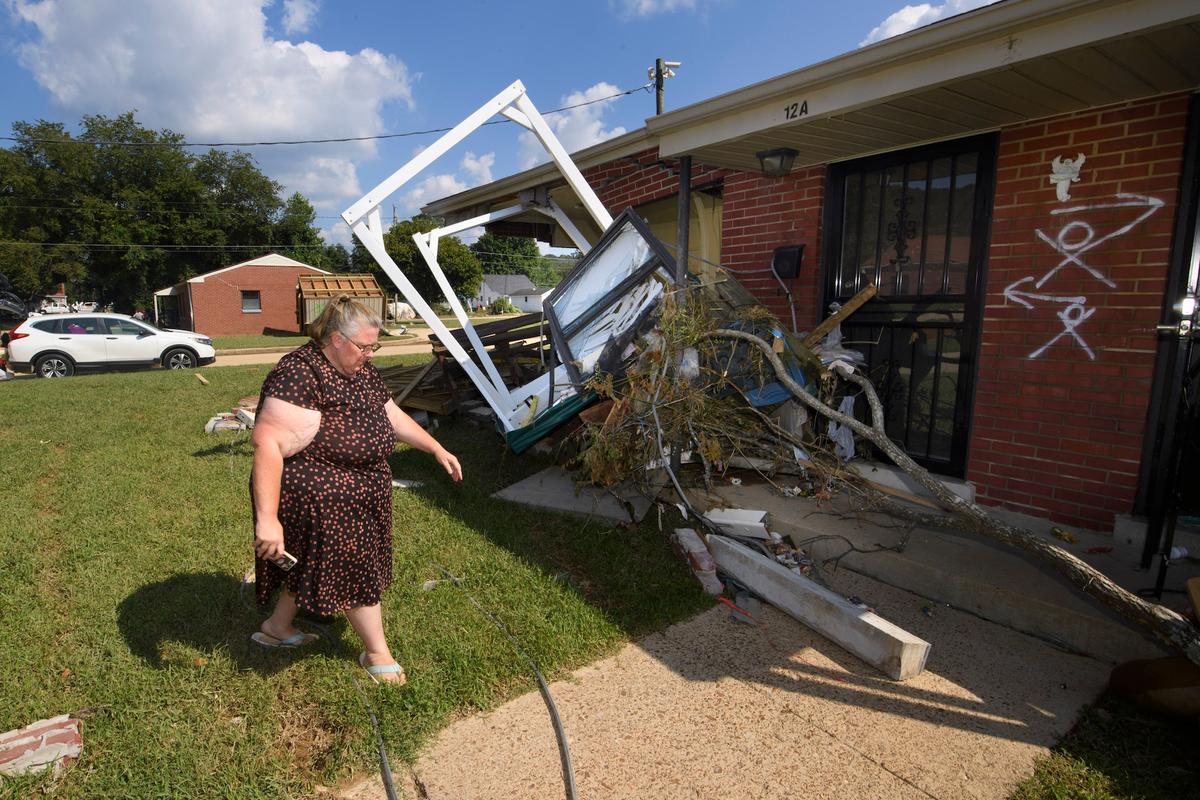 A woman walks up to her home in flood-hit Waverly, Tenn., on Aug. 23, 2021. (AP Photo/John Amis)