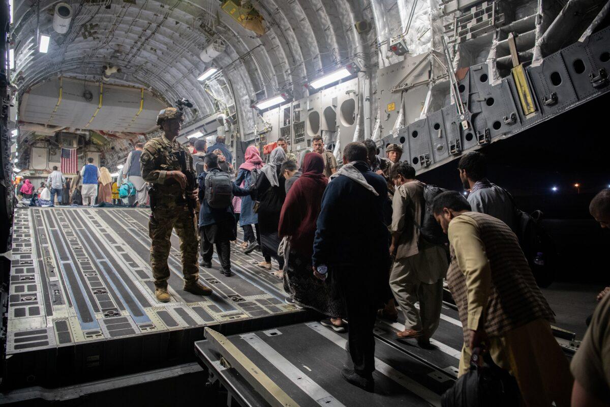 Afghans board a U.S. Air Force C-17 Globemaster III transport plane during an evacuation at Hamid Karzai International Airport, Afghanistan on Aug. 22, 2021. (U.S. Air Force via Reuters)