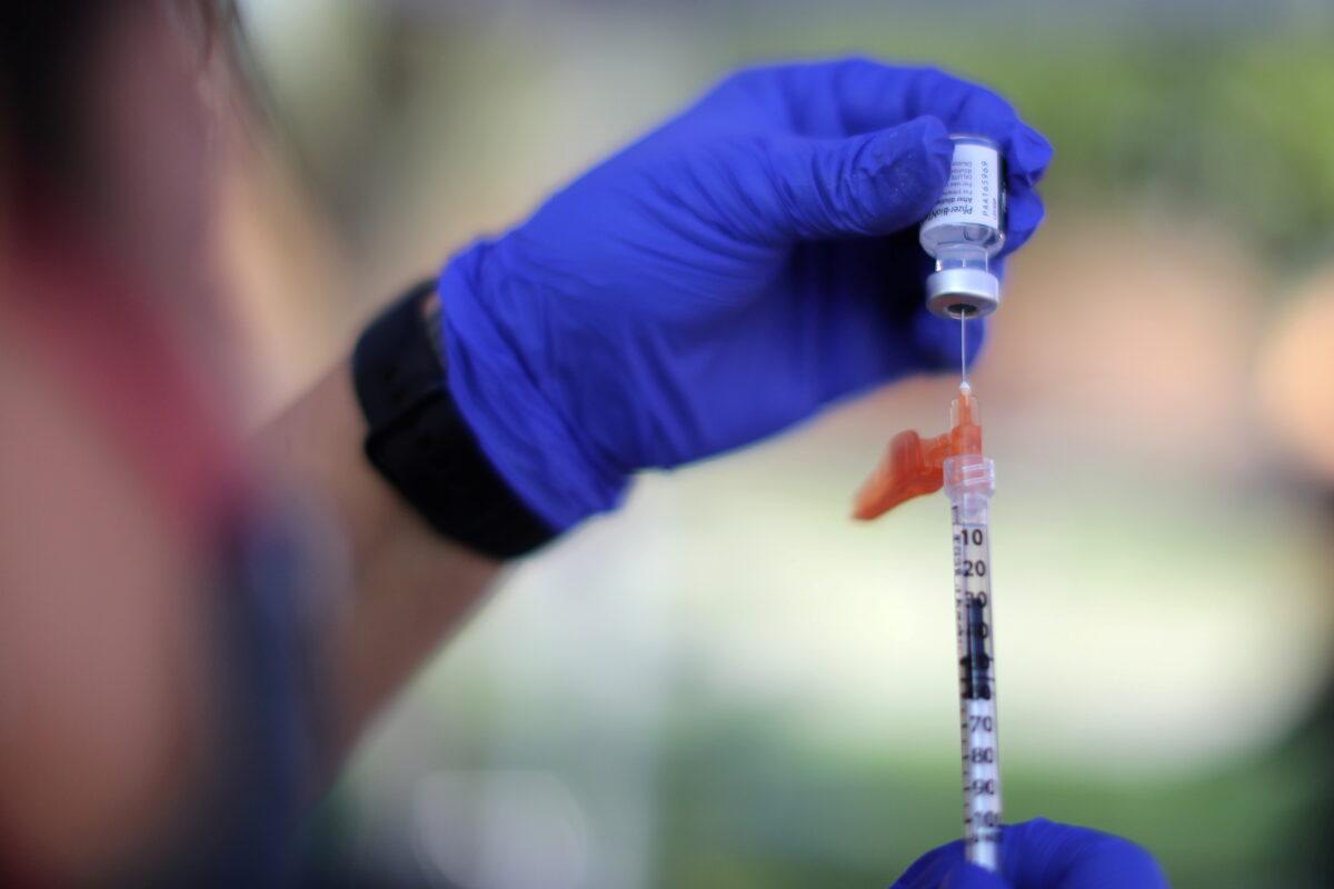 A nurse prepares a Pfizer BioNTech COVID-19 vaccination as part of a vaccine drive by the Fernandeno Tataviam Band of Mission Indians in Arleta, Los Angeles, Calif., on Aug. 23, 2021. (Lucy Nicholson/Reuters)
