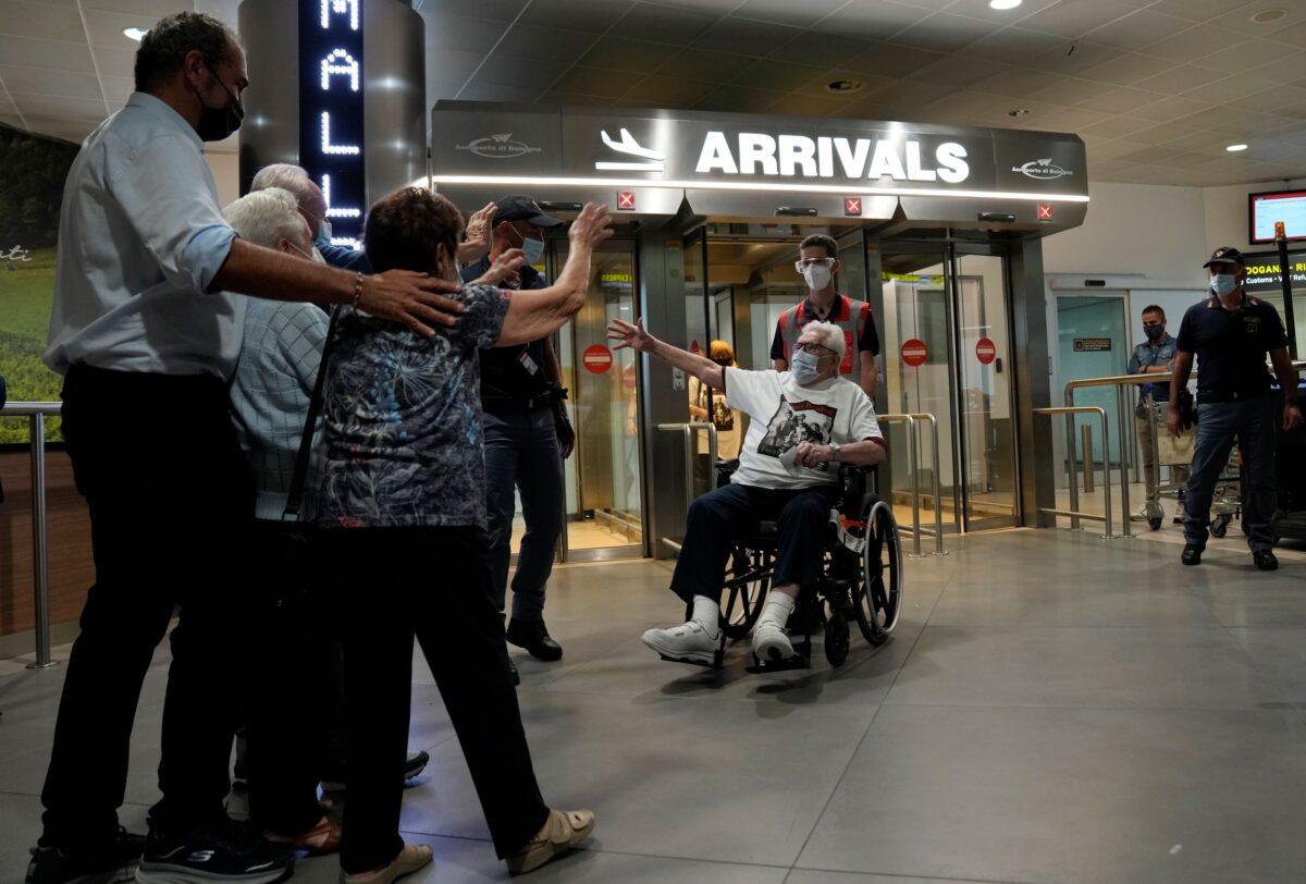 A 97 year old retired American soldier Martin Adler (R) is welcomed upon his arrival by Giulio Mafalda Giuliana Naldi that he saved during WWII at Bologna's airport, Italy, on Aug. 23, 2021. (Antonio Calanni/AP Photo)