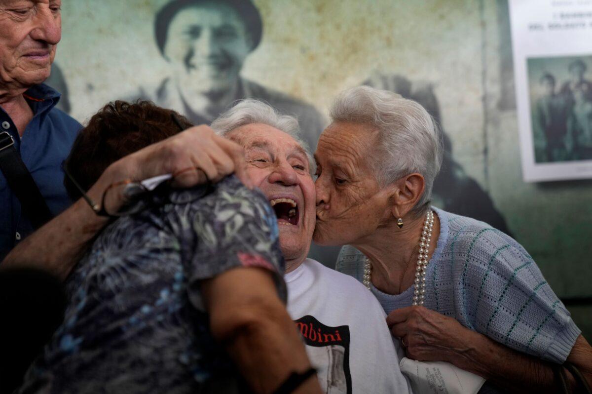 Martin Adler, a 97-year-old retired American soldier (C) receives a kiss from Mafalda (R) and Giuliana Naldi, whom he saved during WWII, during a reunion at Bologna's airport, in Italy, on Aug. 23, 2021. (Antonio Calanni/AP Photo)