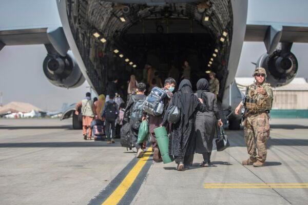 In this image provided by the U.S. Marine Corps, families begin to board a U.S. Air Force Boeing C-17 Globemaster III during an evacuation at Hamid Karzai International Airport in Kabul, Afghanistan, on Aug. 23, 2021. (Sgt. Samuel Ruiz/U.S. Marine Corps via AP)
