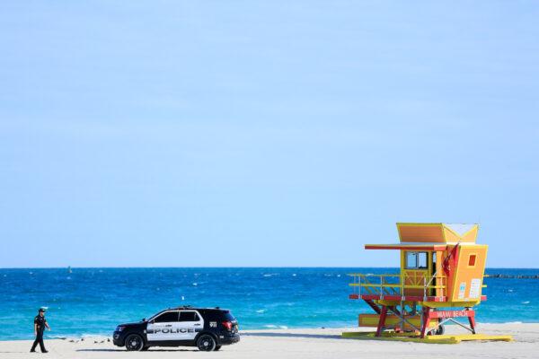 An officer walks toward a police SUV next to the third street lifeguard stand on Miami Beach, Florida, on March 22, 2020. (Cliff Hawkins/Getty Images)