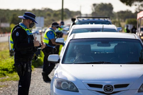 A police force member inspects cars at a Border Check Point on Indian Ocean Drive, north of Perth in Western Australia, Australia, on June 29, 2021. (Photo by Matt Jelonek/Getty Images)
