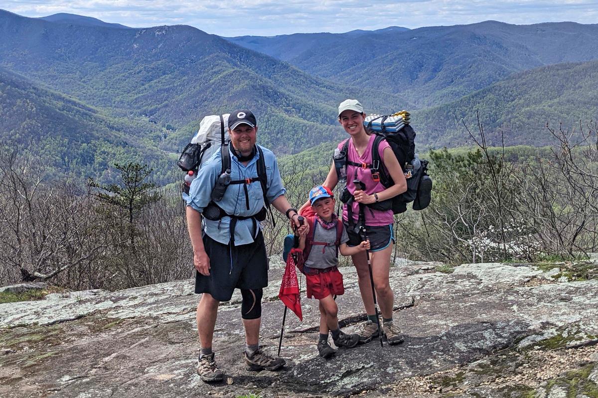 Five-year-old Harvey Sutton (C) poses with his mom Cassie (R) and dad Joshua on a mountain top in Three Ridges, Virginia, on April 11, 2021. (Joshua Sutton/AP Photo)