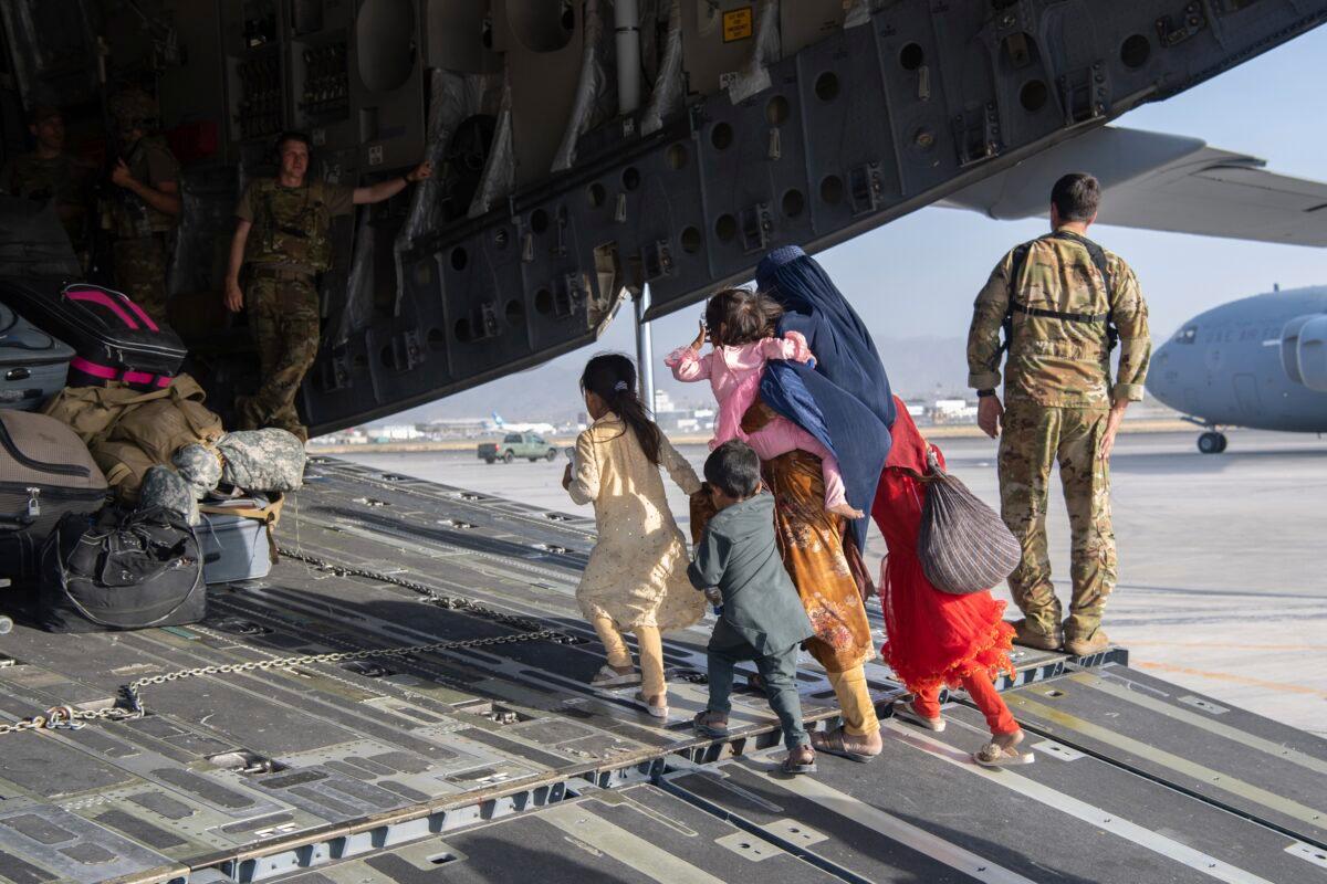 U.S. Air Force loadmasters and pilots, assigned to the 816th Expeditionary Airlift Squadron, load people being evacuated from Afghanistan onto a U.S. Air Force C-17 Globemaster III at Hamid Karzai International Airport in Kabul, Afghanistan, on Aug. 24, 2021. (Master Sgt. Donald R. Allen/U.S. Air Force via AP)