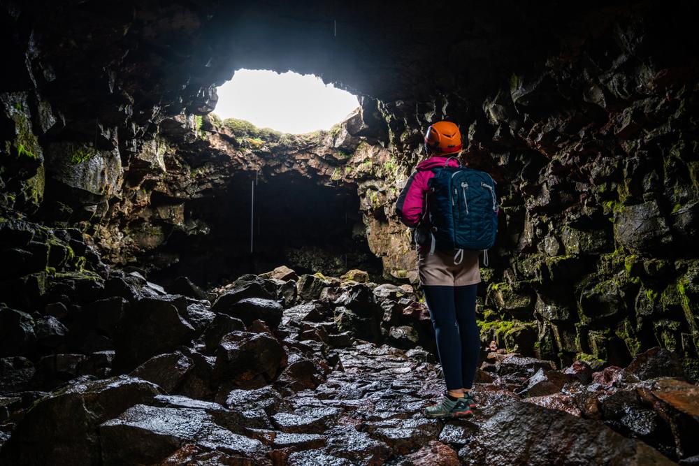 A woman explores the Raufarholshellir lava tunnel. (Blue Planet Studio/Shutterstock)