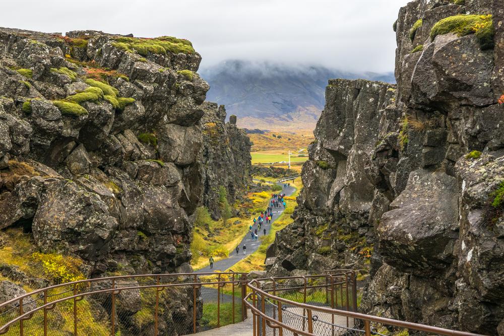 People walk between the Eurasian and North American tectonic plates in Thingvellir National Park. (Nido Huebl/Shutterstock)