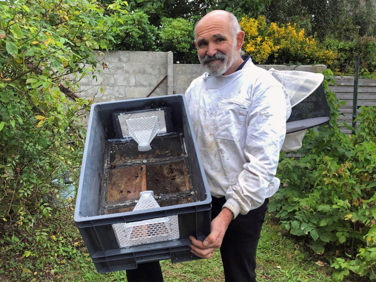 French beekeeper Denis Jaffre poses with his invention, a trap designed to catch Asian giant hornets, an invasive species also known as "murder hornets" that prey on bee colonies, in Pencran, France, on Aug. 18, 2021. (Manuel Ausloos/Reuters)