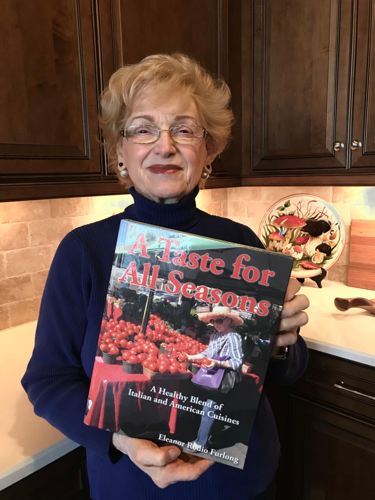 The author with her cookbook, "A Taste for All Seasons," published Feb. 2021. The book is a collection of recipes, family traditions, and memories from her Italian-American upbringing, travels through Italy, and decades of cooking for family and friends. (Courtesy of Eleanor Rodio Furlong)