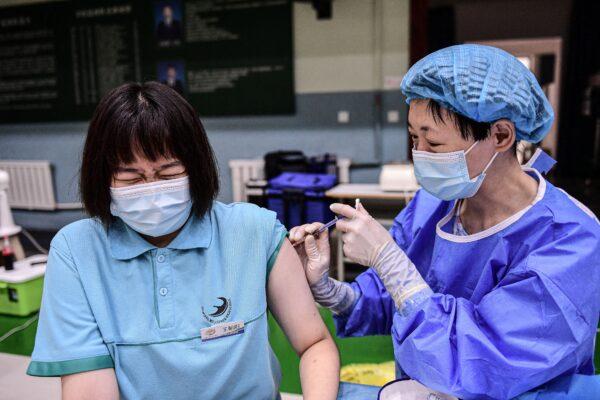 A student reacts as she receives the Sinopharm Covid-19 vaccine at a high school in China's northeastern Liaoning Province on July 28, 2021. (STR / AFP)