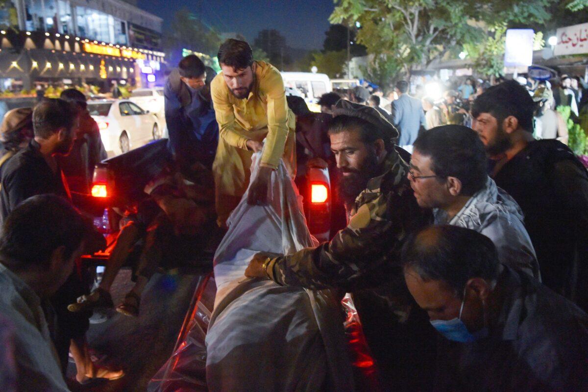 Volunteers and medical staff unload bodies from a pickup truck outside a hospital in Kabul, Afghanistan on Aug. 26, 2021. (Wakil Kohsar/AFP via Getty Images)