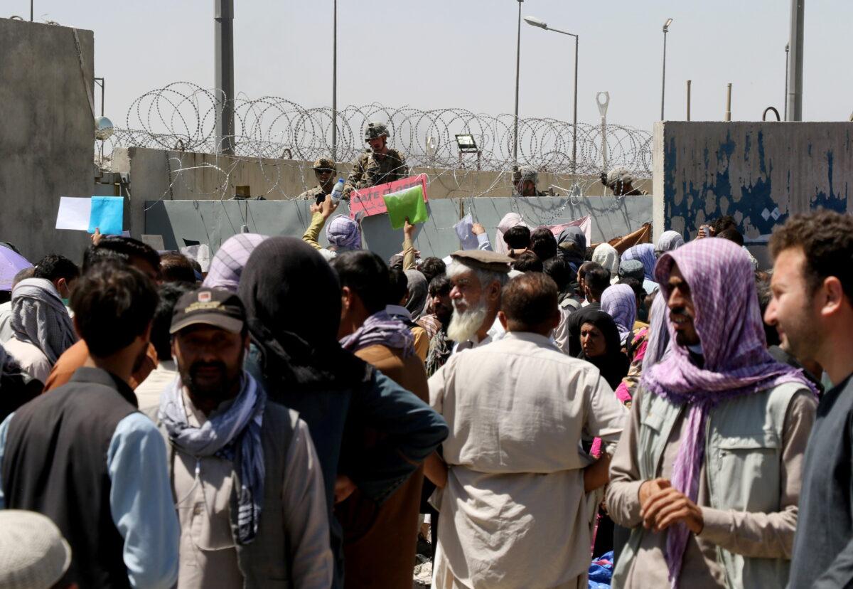 Crowds of people show their documents to U.S. troops outside the airport in Kabul, Afghanistan on Aug. 26, 2021. (Stringer/Reuters)