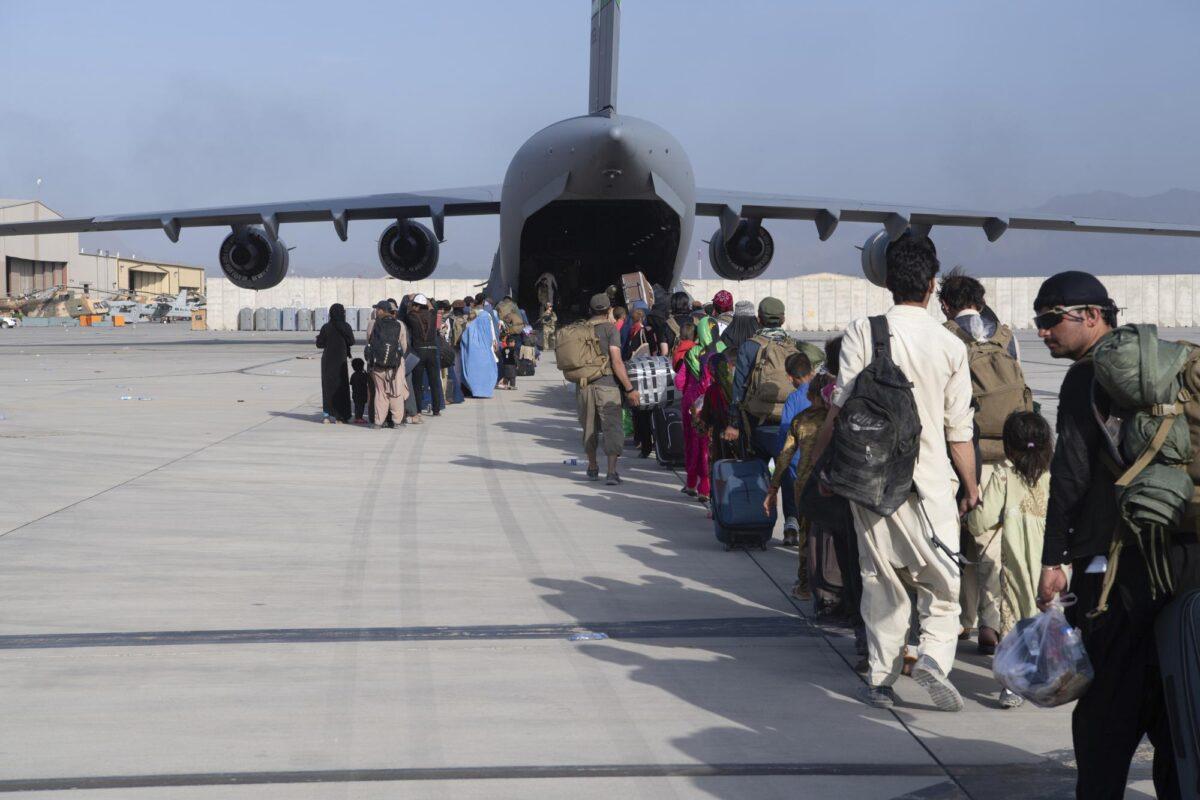 U.S. Air Force loadmasters and pilots assigned to the 816th Expeditionary Airlift Squadron, load people being evacuated from Afghanistan onto a U.S. Air Force C-17 Globemaster III at Hamid Karzai International Airport in Kabul, on Aug. 24, 2021. (Master Sgt. Donald R. Allen/U.S. Air Force via AP)