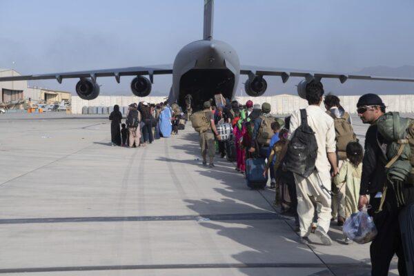 U.S. Air Force loadmasters and pilots assigned to the 816th Expeditionary Airlift Squadron, load people being evacuated from Afghanistan onto a U.S. Air Force C-17 Globemaster III at Hamid Karzai International Airport in Kabul, Afghanistan, on Aug. 24, 2021. (Master Sgt. Donald R. Allen/U.S. Air Force via AP)