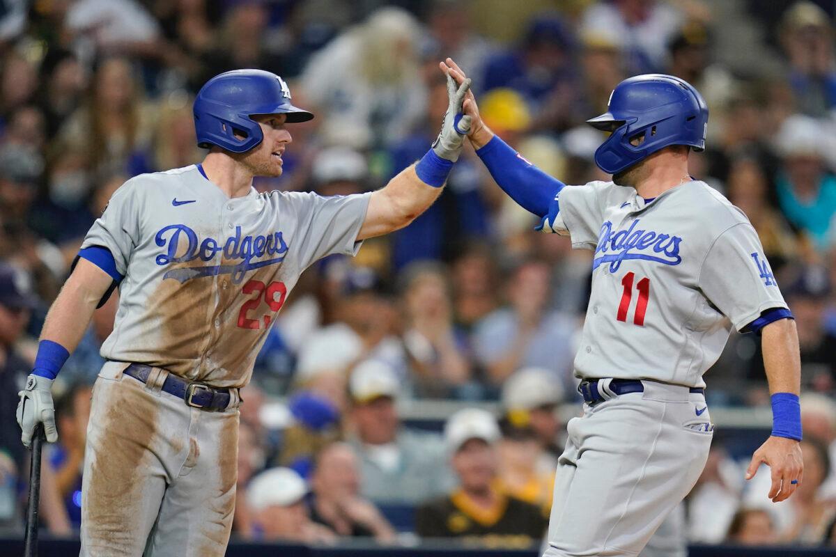 Los Angeles Dodgers' AJ Pollock (11) is greeted by Billy McKinney after scoring from third off a sacrifice fly by Cody Bellinger during the fourth inning of the team's baseball game against the San Diego Padres in San Diego, Calif., on Aug. 26, 2021. (AP Photo/Gregory Bull)