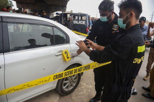 Security officials examine a shot-at vehicle that was carrying Chinese nationals in Pakistan’s port city of Karachi on July 28, 2021. One Chinese national was wounded in a gun attack on the vehicle, police said, in what was one of a number of recent assaults targeting Chinese citizens in the country. (Rizwan Tabassum/AFP via Getty Images)