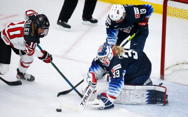 Canada goalie Alex Cavallini (C), of the United States, blocks a shot from Canada's Sarah Fillier as Grace Zumwinkle looks on during first period IIHF Women's World Championship hockey action in Calgary, on Aug. 26, 2021. (Jeff McIntosh/The Canadian Press)