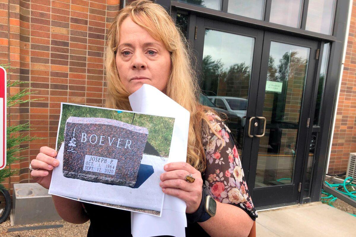 Jane Boever holds a photo of her brother Joseph Boever's tombstone outside the courthouse in Fort Pierre, S.D., on Aug. 26, 2021. (Stephen Groves/AP Photo)
