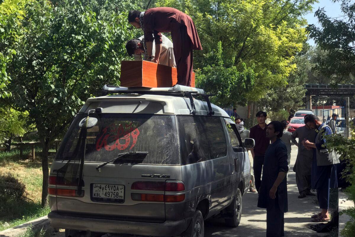 Afghans carry the dead body of an Afghan at a hospital after deadly attacks outside the airport in Kabul, Afghanistan, on Aug. 27, 2021. (Wali Sabawoon/AP Photo)