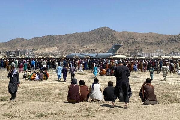 Hundreds of people gather near a U.S. Air Force C-17 transport plane at the perimeter of the international airport in Kabul, Afghanistan, on Aug. 16, 2021. (Shekib Rahmani/AP Photo)