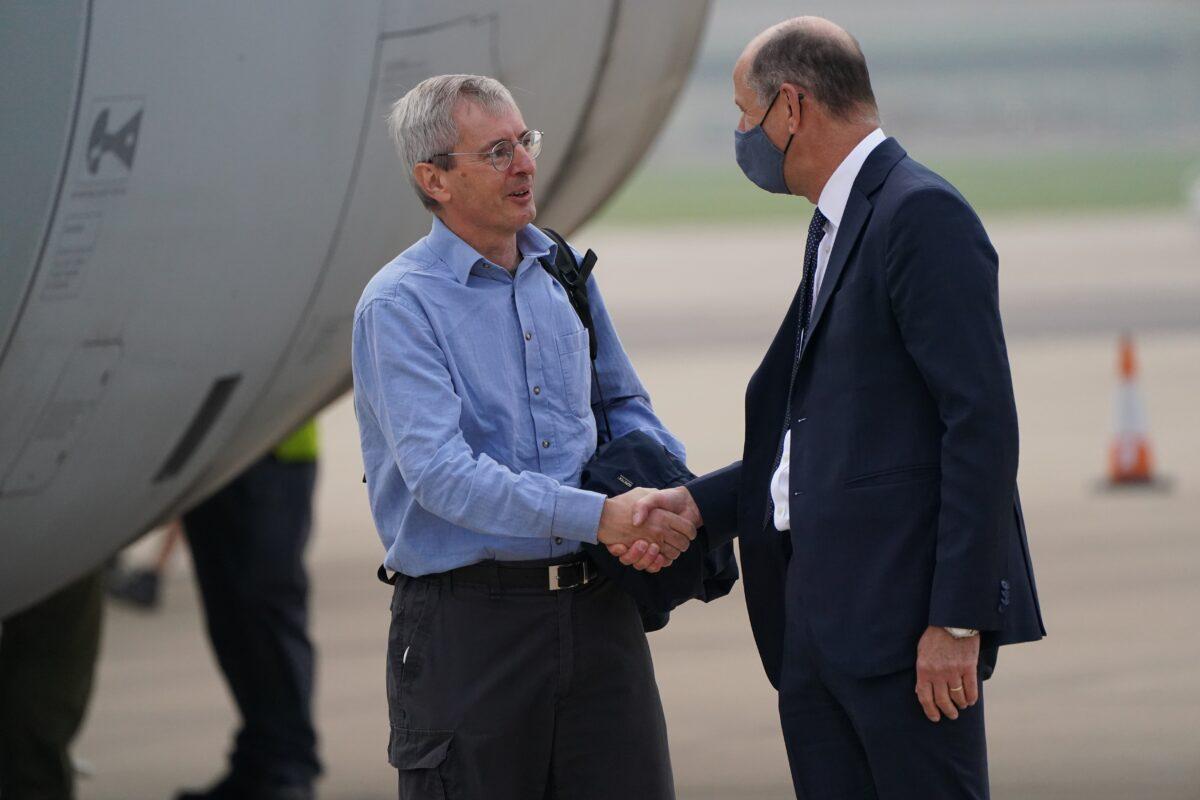 Ambassador to Afghanistan Sir Laurie Bristow (left) is greeted by Sir Philip Barton, Permanent Under-Secretary of the Foreign, Commonwealth and Development Office, as he exits a plane after being evacuated from Kabul, upon its arrival at RAF Brize Norton base in Oxfordshire, UK, on Aug. 29, 2021. (Jonathan Brady/PA)