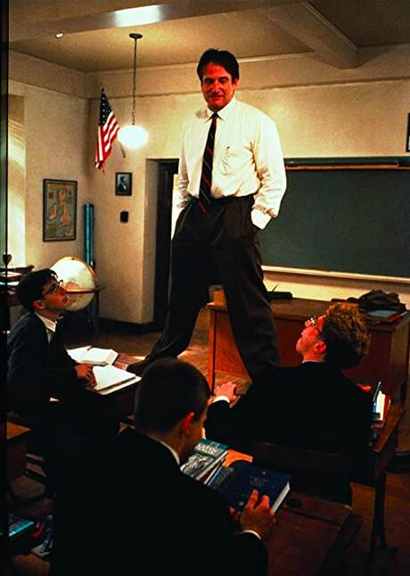 John Keating (Robin Williams) stands on a desk to demonstrate to his English class prep school students how to get a different perspective on life, in "Dead Poets Society." (Touchstone Pictures/Warner Bros)