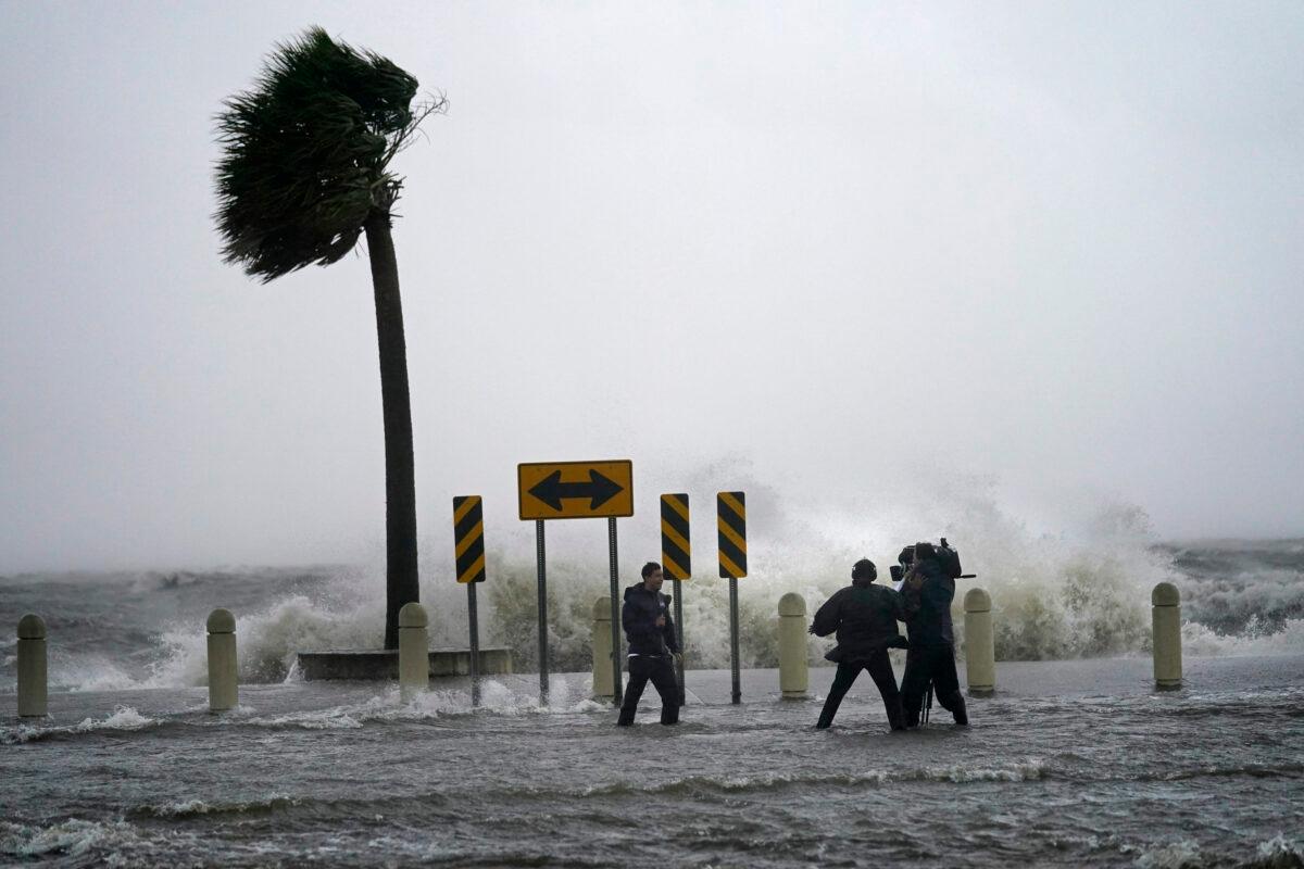 A news crew reports on the edge of Lake Pontchartrain ahead of approaching Hurricane Ida in New Orleans, on Aug. 29, 2021. (Gerald Herbert/AP Photo)