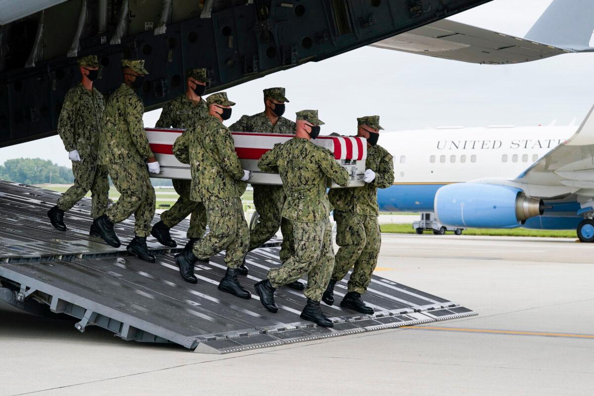 A Navy carry team moves a transfer case containing the remains of Navy Corpsman Maxton W. Soviak, 22, of Berlin Heights, Ohio, on Aug. 29, 2021, during a casualty return at Dover Air Force Base, Del. (Manuel Balce Ceneta/AP Photo)