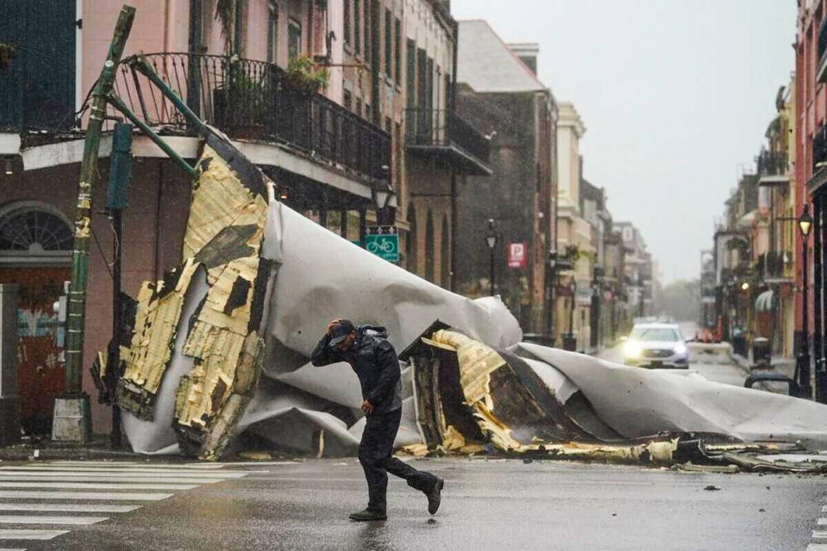 A man passes by a section of roof that was blown off of a building in the French Quarter by Hurricane Ida winds, in New Orleans, La., on Aug. 29, 2021. (Eric Gay/AP Photo)