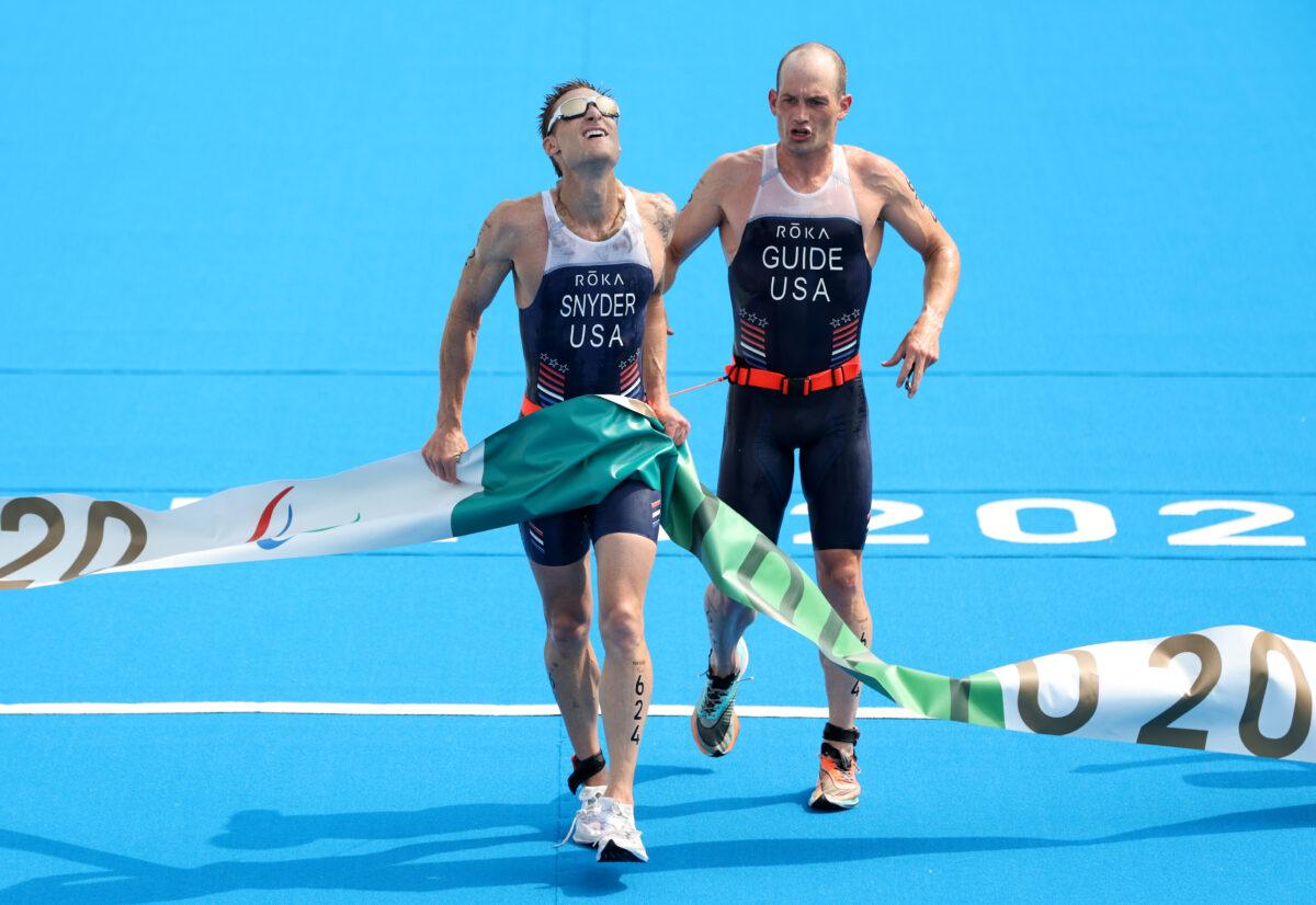 Brad Snyder and guide Greg Billington of Team USA react as they cross the finish line to win the gold medal during the men's PTVI Triathlon on day 4 of the Tokyo 2020 Paralympic Games at Odaiba Marine Park on Aug. 28, 2021 in Tokyo, Japan. (Adam Pretty/Getty Images)