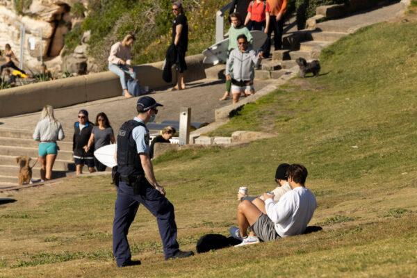 A police officer speaks to a member of the public as part of public health order compliance operations at Bondi Beach in Sydney, Australia, on Aug. 15, 2021. (Brook Mitchell/Getty Images)