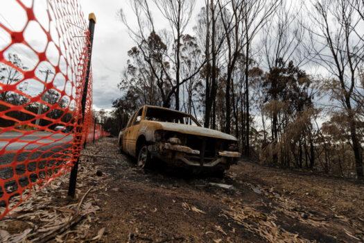 A burnt-out vehicle is seen on Thompsons Drive in Tathra, New South Wales, on Mar. 25, 2018. (Brook Mitchell/Getty Images)