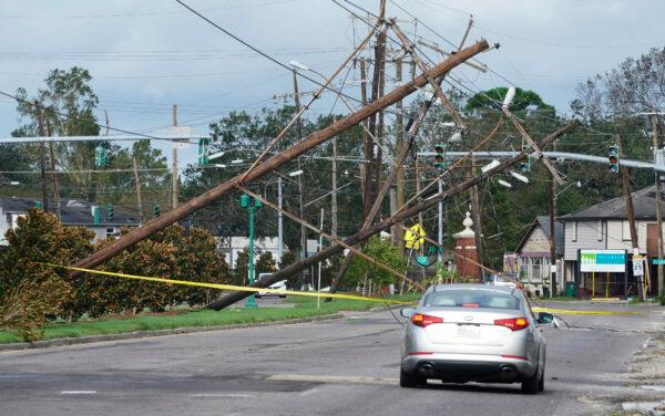 Traffic diverts around power poles that hang over a road after Hurricane Ida moved through Metairie, La., on Aug. 30, 2021. (Steve Helber/AP Photo)