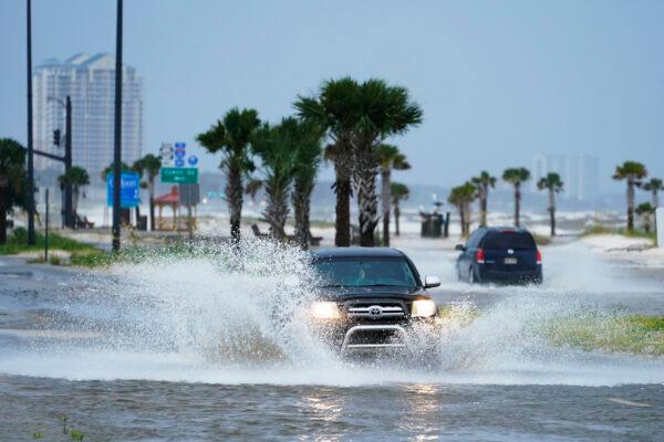 Cars drive through flood waters along route 90 as outer bands of Hurricane Ida arrive in Gulfport, Miss., on Aug. 29, 2021. (AP Photo/Steve Helber)