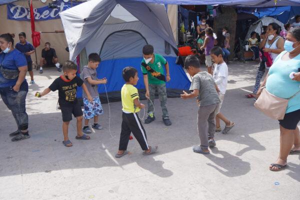 Children play with "trompos" in the refugee camp in Reynosa, Mexico, on Aug. 28, 2021. (Jackson Elliott/The Epoch Times)