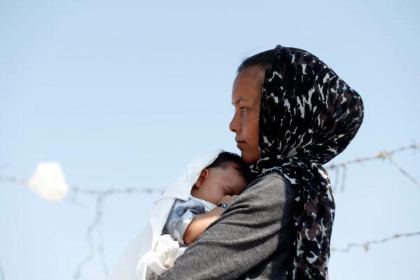 An Afghan woman and her month-old son are seen outside the new temporary camp for migrants and refugees, on the island of Lesbos in Greece, on Sept. 21, 2020. (Yara Nardi/Reuters)