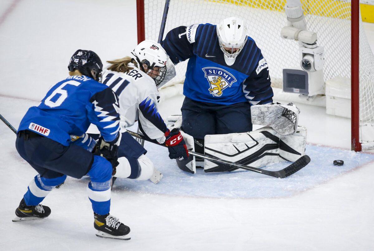 Finland goalie Anni Keisala, right, blocks a shot from Brianna Decker, center, of the United States, as Finland's Petra Nieminen checks Decker during the first period of an IIHF women's hockey championships semifinal in Calgary, Alberta on Aug. 30, 2021. (Jeff McIntosh/The Canadian Press via AP)