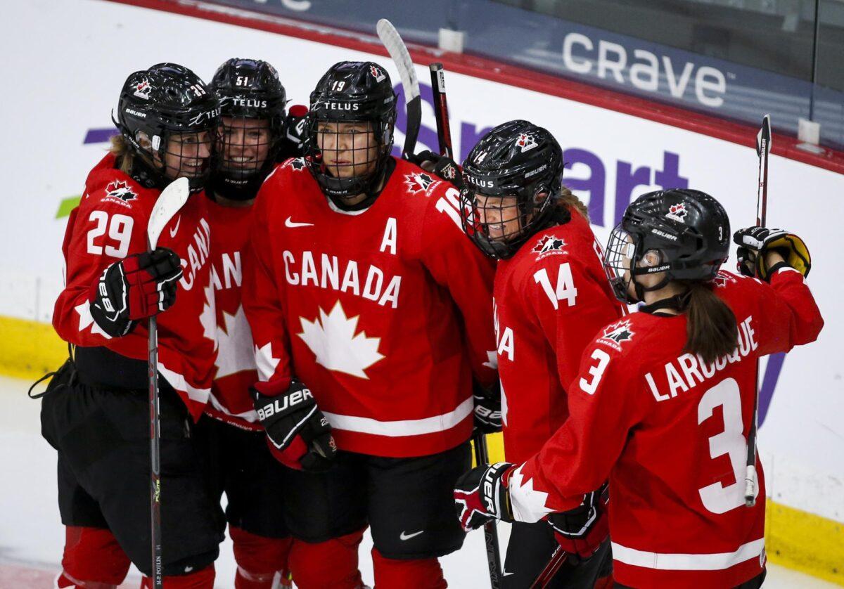 Canada's Renata Fast (14) celebrates her goal against Switzerland with teammates during the first period of an IIHF women's hockey championships semifinal in Calgary, Alberta, on Aug. 30, 2021. (Jeff McIntosh/The Canadian Press via AP)