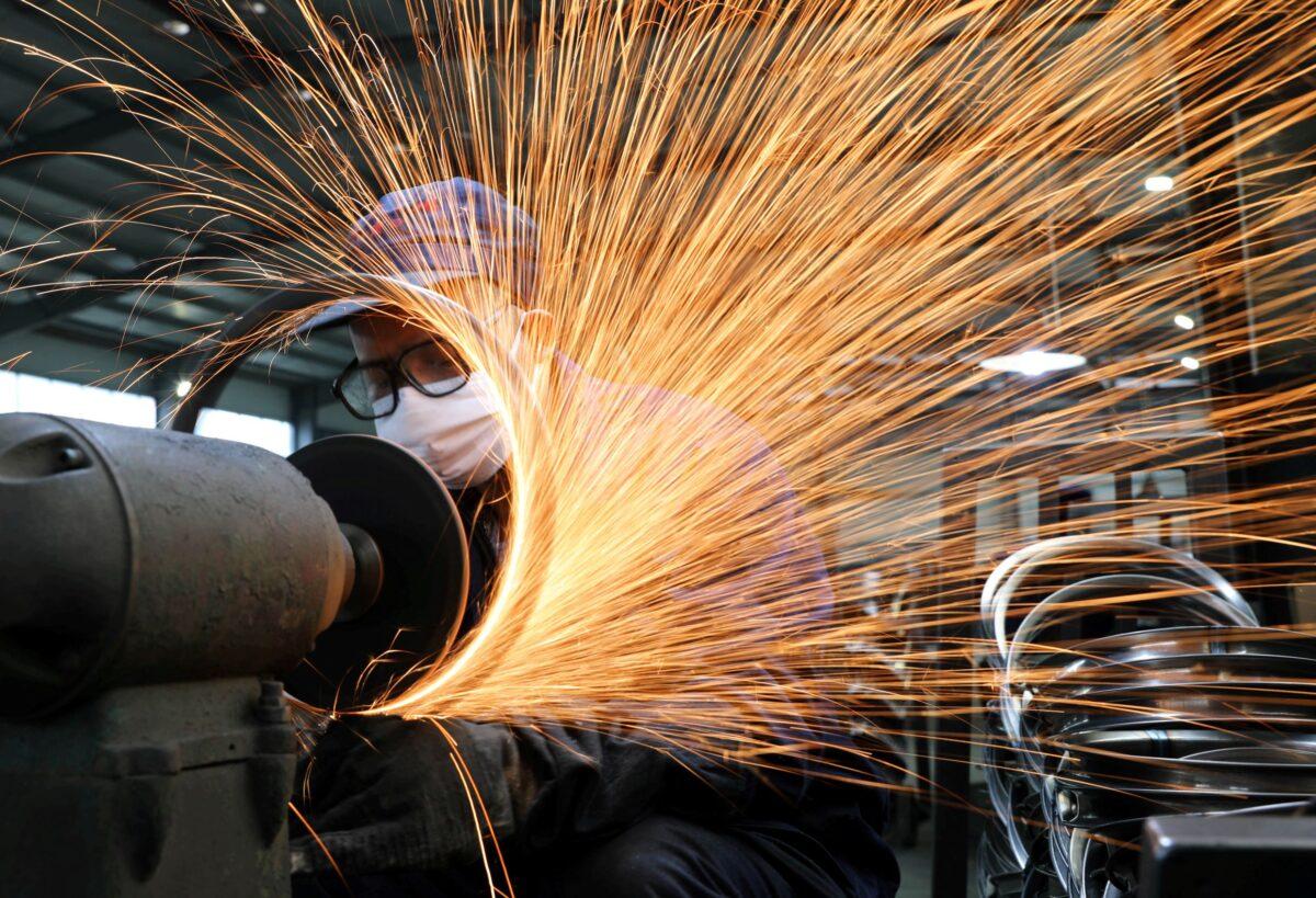 A worker works on a production line manufacturing bicycle steel rims at a factory, as the country is hit by the COVID-19 outbreak, in Hangzhou, Zhejiang Province, China, on March 2, 2020. (China Daily via Reuters)